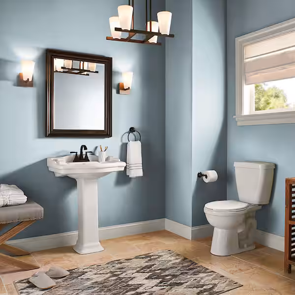 Blue paint colors for bathroom: Modern bathroom featuring powder blue walls, white pedestal sink, bronze fixtures, and warm wood accents. Area rug and natural lighting create an inviting spa-like atmosphere